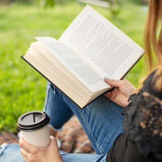 Frau liest draußen ein Buch