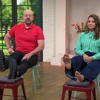 Physiotherapeut Kai Becker und Moderatorin Fatma Mittler-Solak machen Fitnesübungen