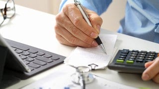 Mann rechnet mit Taschenrechner: Ob sich die Kosten für eine Zusatzversicherung im Bereich Gesundheit oder Pflege lohnen, hängt von den persönlichen Bedürfnissen ab und muss im Einzelfall nachgerechnet werden.