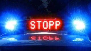Blaulicht und Leuchtschrift "Stopp" auf einem Polizeiauto. In Worms hat sich ein Fahrer eine Verfolgungsjagd mit der Polizei geliefert (Symbolbild)