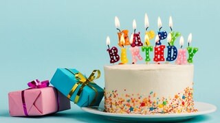 Ein Geburtstagskuchen mit Kerzen und Geschenken