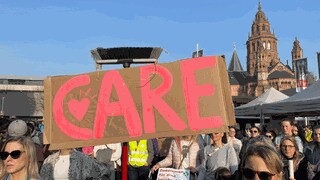 Frauen demonstrieren mit Plakaten auf dem Gutenbergplatz in Mainz für Gleichstellung und soziale Gerechtigkeit