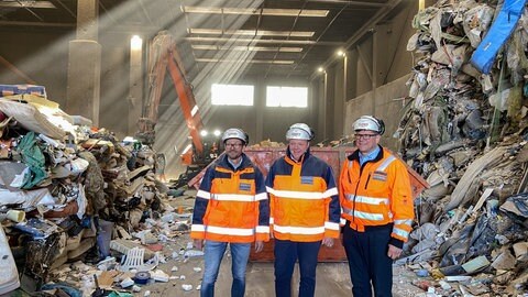 Drei Mitarbeiter der Firma Korn Recycling in Albstadt stehen in einer Halle mit unsortierten Müllbergen. Darunter befinden sich immer wieder Akkus.