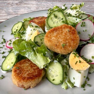 Kopfsalat und Joghurtdressing und Räucherfischfrikadellen