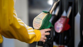 Eine Frau hält eine Zapfpistole