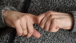 Ein Mann versucht, seine Fingergelenke knacken zu lassen: Ist Fingerknacken schädlich? Und was knackt da eigentlich genau?