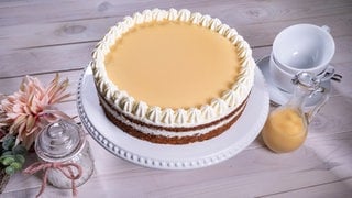 Die glutenfreie Eierlikörtorte mit saftigem Nussboden ist, wie im Rezept beschrieben, schön auf einer Kaffeetafel angerichtet.