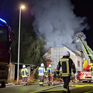 Die Feuerwehr bei Löscharbeiten an einem Wohnhaus