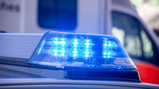 Symbolbild: Blaulicht der Polizei vor einem Krankenwagen