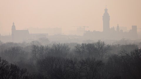Der Saharastaub verändert unsere Atmosphäre: Über einer Stadt hängen rötlich scheinende Wolken. Ein Grund für Wissenschaft und Forschung Saharastaub-Ereignisse unter die Lupe zu nehmen.