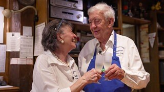 Ein Ehepaar. Sie ist 80 Jahre alt, er 85. Sie schauen sich an, lächeln und prosten sich mich Sektgläsern zu. 