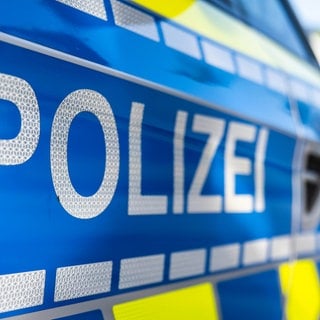 An der Tür von einem Streifenwagen steht der Schriftzug «Polizei». 