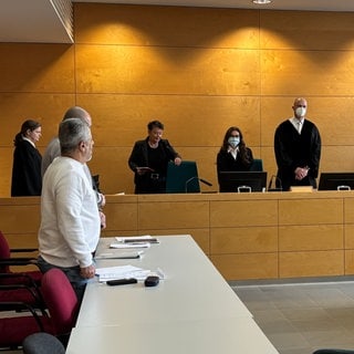 Prozessauftakt am Landgericht Kaiserslautern: Ein Mann soll in der Afa Kusel zwei Mitbewohner mit einem Messer schwer verletzt haben. Im Vordergrund sein Dolmetscher (weißer Pullover).