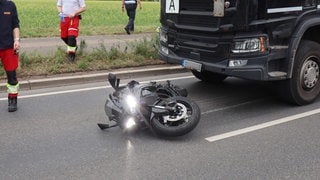 Ein schwarzes Motorrad liegt auf der B44 bei Mannheim vor einem schwarzen Lkw. Die 28-jährige Fahrerin starb nach einem Zusammenstoß mit dem Lkw.