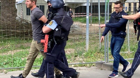 Einer der vermeintlichen Attentäter der Amokübung an der Uniklinik freiburg wird von Polizisten abgeführt