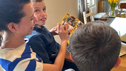Mattia liebt es sich Fotos aus dem Familienalbum anzuschauen. Mama Dina und Bruder Linus machen mit. 