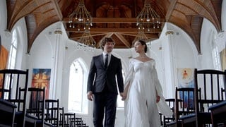 Ein Hochzeitspaar ist in einer Kirche zu sehen