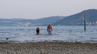 Menschen baden im Bodensee vor Konstanz-Wallhausen.