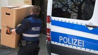 Polizist sichert Material bei einer Hausdurchsuchung. Auch in RLP ist die Polizei am Donnerstag gegen die Verbreitung von Kinderpornografie vorgegangen.