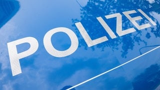 Weißer Schriftzug "Polizei" auf dem blauen Untergrund eines Dienstwagens - in Metzingen hat die Polizei einen Dreijährigen in einem Saftfass gefunden