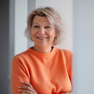 Claudia Oterkamp-Baerens blickt lächelnd in die Kamera.