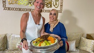 Susanne Nett und Layla Bendraaou posieren in Mainz-Bretzenheim mit ihrem traditionellen Couscous mit Hähnchen aus Marokko.