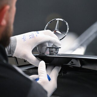 Ein Arbeiter bei Mercedes-Benz montiert im Mercedes-Benz-Werk Sindelfingen in der Factory 56 einen Mercedes-Stern auf ein Fahrzeug der S-Klasse. Die IG Metall lehnt eine 38-Stunden-Woche ab und will bei 35 Stunden bleiben.