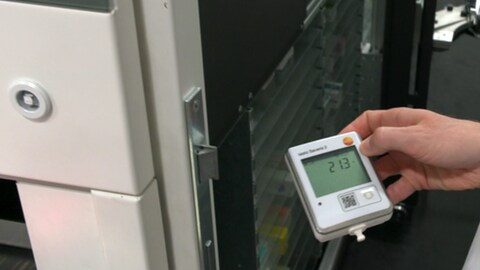 Medikamente bei Hitze: Ein Apotheker misst mit einem Thermometer die Temperatur im Lager der Apotheke. Die Temperatur beträgt 21.3 Grad Celsius.