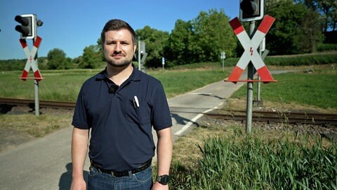 AVG-Stadtbahnfahrer steht vor einem Bahnübergang. Er ist für seine Zivilcourage mit einem Preis ausgezeichnet worden.