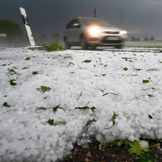 Hagel liegt auf der Straße. Ein Unwetter hatte sich zuvor in der Region um Laupheim (Kreis Biberach)  mit Blitz und Hagel entladen.