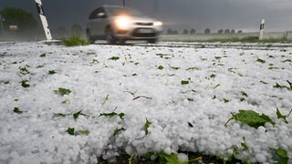 Hagel liegt auf der Straße. Ein Unwetter hatte sich zuvor in der Region um Laupheim (Kreis Biberach)  mit Blitz und Hagel entladen.
