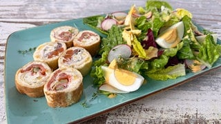 Gefüllte Crêperöllchen auf Salat mit Ei