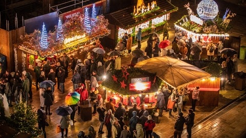 Besucher laufen über den Stuttgarter Weihnachtsmarkt.