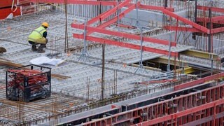 Bauarbeiter arbeiten an einem Rohbau für Eigentumswohnungen.