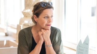 Jule Ronstedt im Interview: Die Schauspielerin stützt nachdenklich das Kinn auf die Hände und schaut aus dem Fenster.