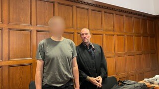 Der Angeklagte aus Eich (Gesicht verpixelt) steht mit seinem Verteidiger vor dem Mainzer Landgericht.