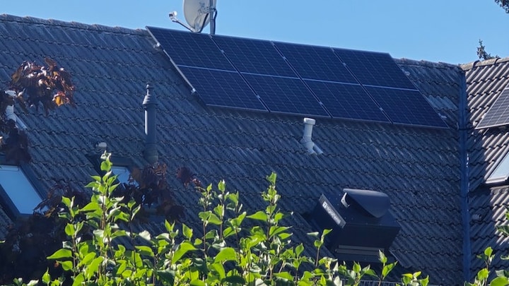 Unterhalb von Solarmodulen befindet sich das Dachmodul einer Wärmepumpe. 