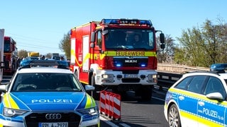 Polizei- und Feuerwehrwagen stehen nach dem Unfall in Höhe Mainz-Lerchenberg auf der A60.