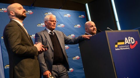 Die beiden Co-Vorsitzenden des AfD-Landesverbandes Baden-Württemberg, Emil Sänze (Mitte) und Markus Frohnmaier (rechts), sprechen beim Landesparteitag in Rottweil neben Reimond Hoffmann zu Parteimitgliedern.