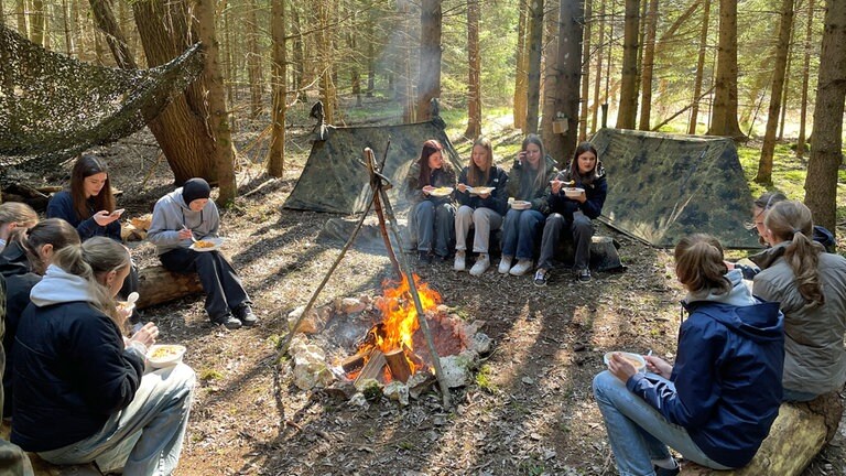 Leben im Feld. Am Lagerfeuer durften die Mädchen die Feldküche testen. Dort berichteten Soldatinnen aus ihrem Alltag als Frau bei der Bundeswehr. 