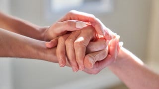 Hände halten von Seniorin als Symbol für Unterstützung und Beistand im Hospiz bei Sterbehilfe | Welthospiztag am 11. Oktober 2025: Ehrenamt im Hospiz: Warum Carlotta Merx Sterbende begleitet