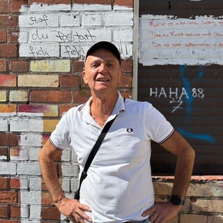 Robert Azari vor einer roten Wand in der Bayreuther Straße.