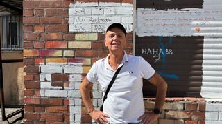 Robert Azari vor einer roten Wand in der Bayreuther Straße.