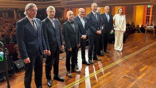 Die acht Kandidierenden für das Amt des Oberbürgermeisters in Baden-Baden auf der Kurhausbühne