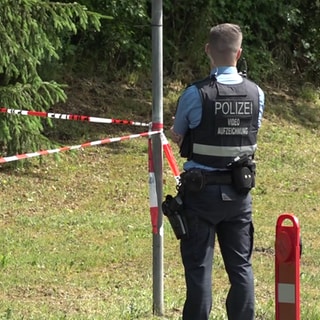 Ein Polizist in der Nähe des Ortes, wo die mutmaßlich getötete Frau in ihrem Wagen gefunden wurde. Die 29-Jährige aus Wirft starb an mehreren Stichverletzungen.