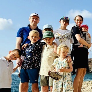 Familie Beranek - Vater, Mutter und sieben Kinder stehen auf einem Felsen am Meer