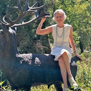 Marion von Gienanth auf einer Hirsch-Statue im Landschaftspark Friedrich von Gienanth in Eisenberg