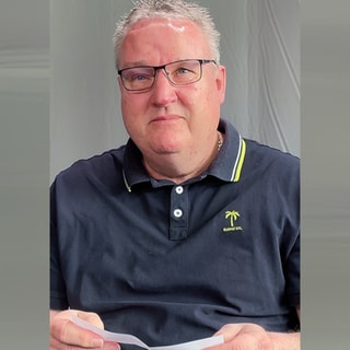 Mann sitzt am Tisch und liest Kommentare, die ihn sehr berühren