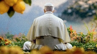 Ein Papst sitzt in weißer Soutane auf einem Rasen, dem Betrachter den Rücken zugewandt, umringt von Blumen und Zitronen und blickt in Richtung Meer und Amalfiküste.