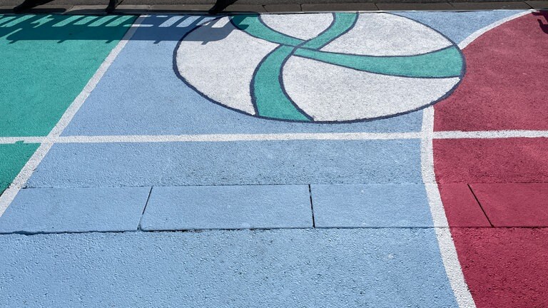 Entlang des Hafens in Konstanz sind bunte Bilder aufgemalt, man sieht sportliche Motive wie Bälle.